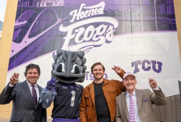 Photograph of President Daniel W. Pullin, SuperFrog, designer Trevor Scott ’22 and Chancellor Victor J. Boschni, Jr. holding up the TCU hand sign as they stand in front of Scott's TCU mural in downtown Fort Worth.