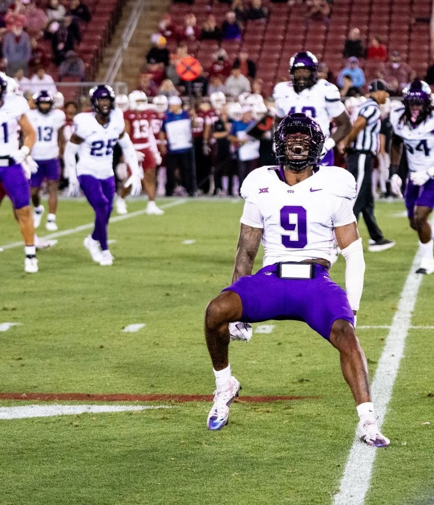 Photo of Marcel Brooks celebrating on the field of Stanford Stadium during TCU Football's 2024 season opener against the Cardinal. Brooks wears a purple TCU football helmet and white jersey, purple football pants and white cleats. 