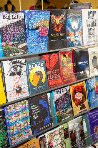 A photograph of a store bookshelf displaying a collection of 15 to 16 hardcover and paperback books, arranged neatly.