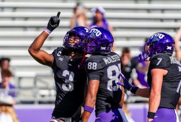 Photograph of TCU wide receiver Savion Williams pointing to the sky in celebration as teammates Eric McAlister and JP Richardson celebrate with him during a 2024 college football game against Texas Tech.