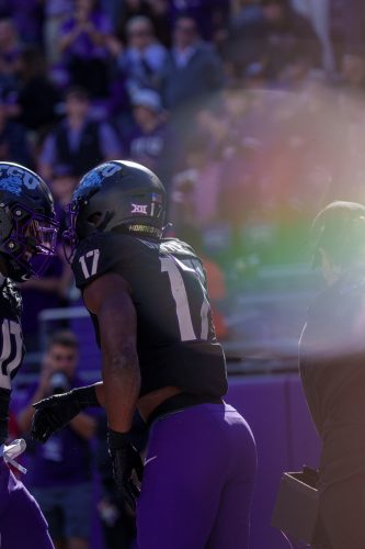 Photograph of TCU football player Trent Battle celebrating a play with teammate DJ Rogers during an NCAA football game against Arizona University on Nov. 23, 2024, in Fort Worth, Texas.