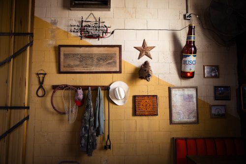 A set showing the interior of a Fort Worth bar from the Paramount+ series “Landman,” complete with all the trappings of a Texas bar — from a Busch beer sign to a cowboy hat.