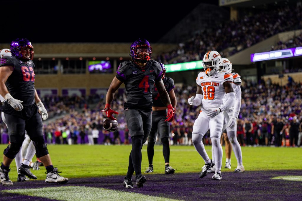 TCU running back Cam Cook dropping the football as he walks through the end zone after scoring a touchdown against Oklahoma State in a November 2024 Big 12 game in Fort Worth, Texas.