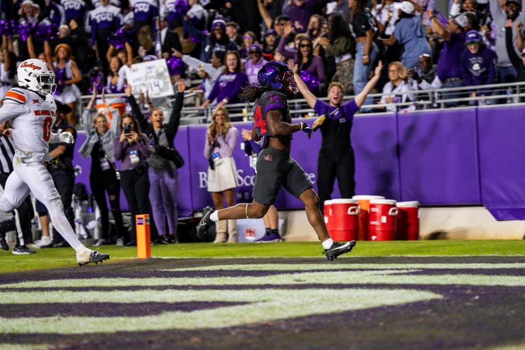 TCU’s Jordyn Bailey running into the end zone for a touchdown during a November 2024 Big 12 game against Oklahoma State, with cheering fans in the background.