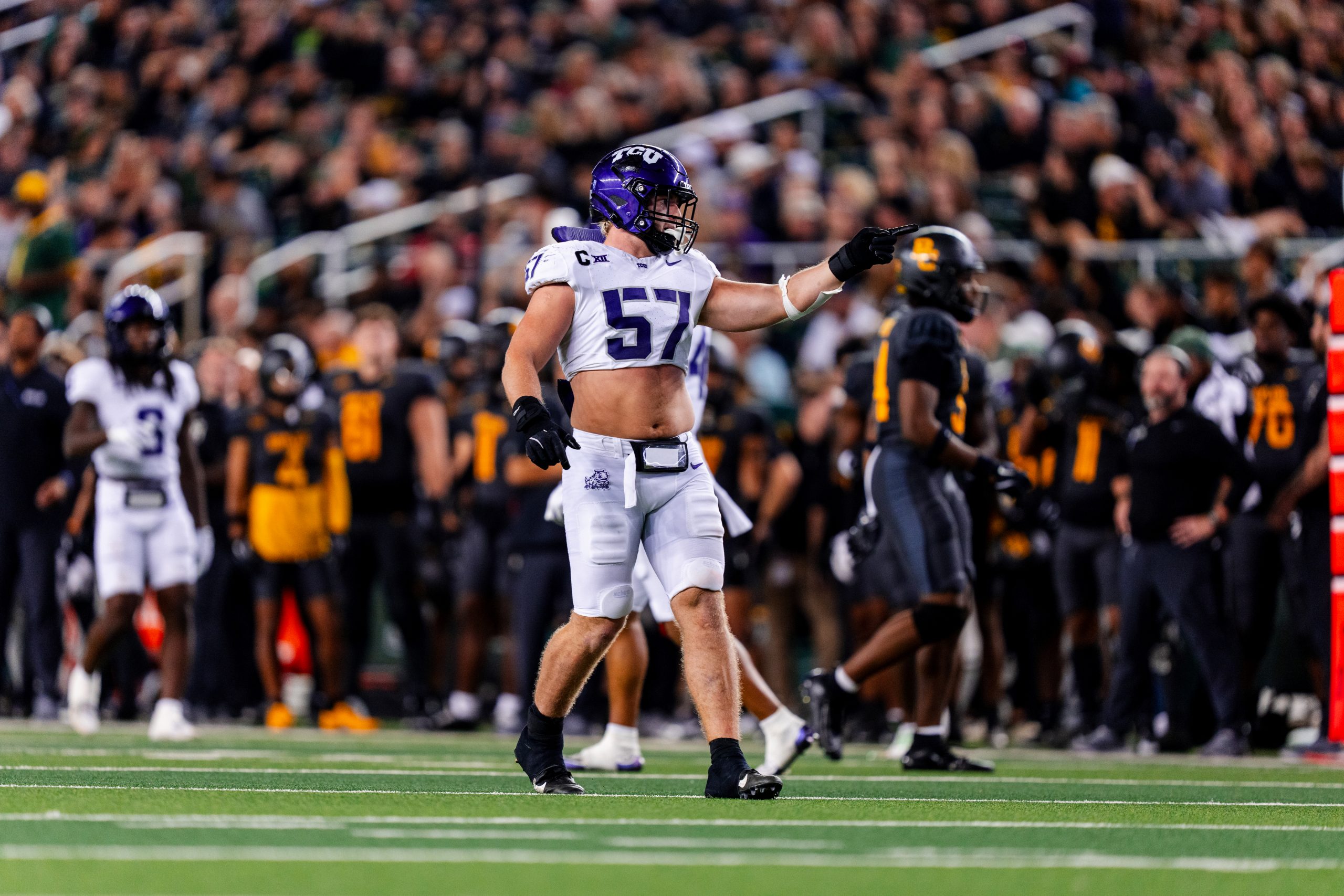 Photograph of TCU football player Johnny Hodges standing on the field of McLane Stadium in Waco, Texas, during a 2024 game against Baylor. Hodges’ left hand is extended as he looks toward the sideline. 