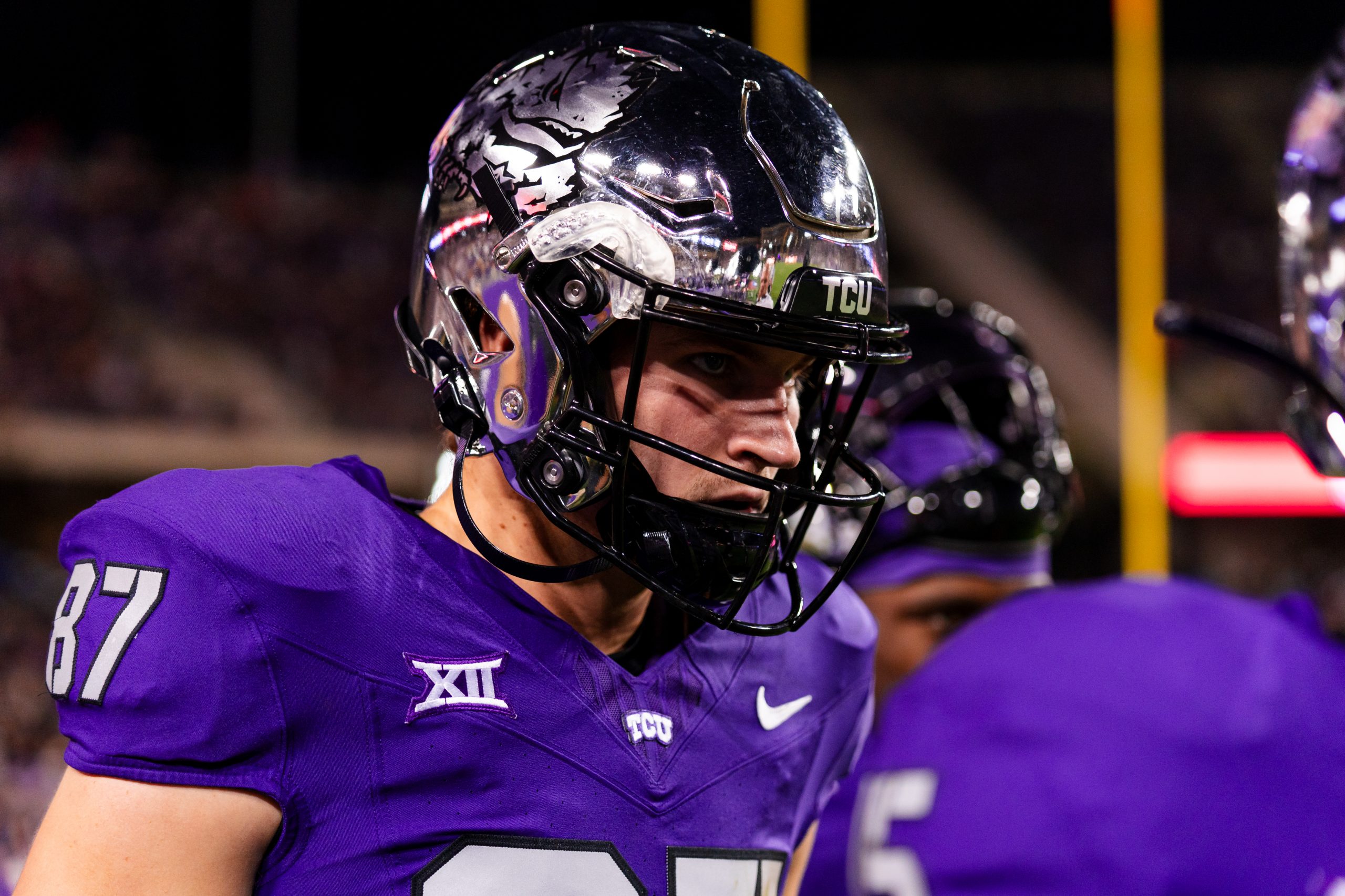 Close-up photograph of TCU wide receiver Blake Nowell during a football game at Amon G. Carter Stadium in Fort Worth, Texas. Nowell, wearing a chrome TCU helmet and purple jersey, looks toward the ground.