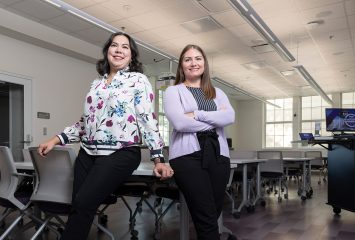 Taryn Ozuna Allen and Stephanie Cuellar pose in a classroom on the TCU campus