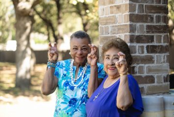 Photograph of Joyce Goff and Hortencia Laguna holding up the “Go Frogs” hand sign.