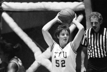 Photograph of TCU women’s basketball great Janice Dziuk holding the ball above her head with both hands during an NCAA game.