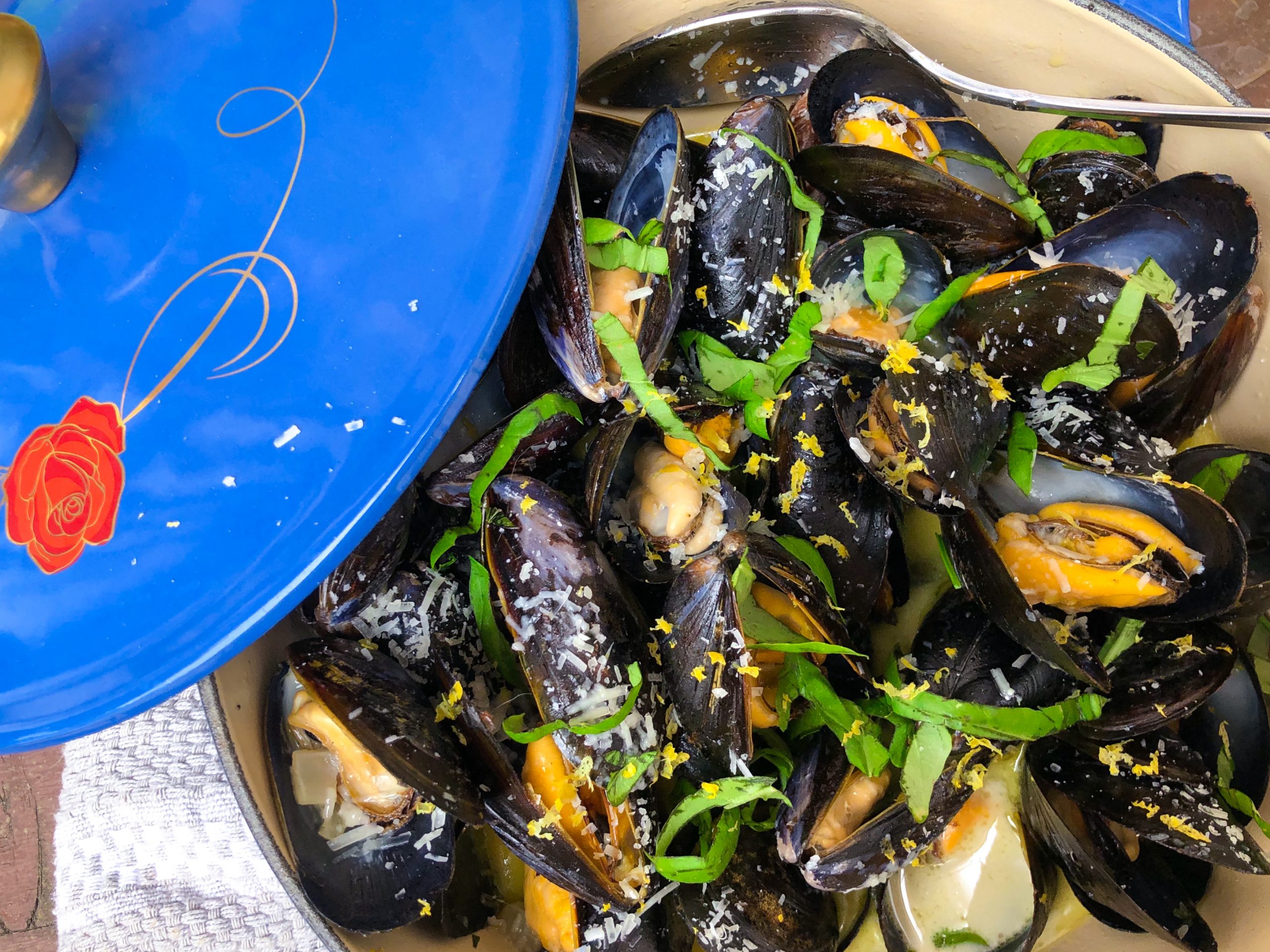 Photograph of seasoned muscles resting in a blue pan.