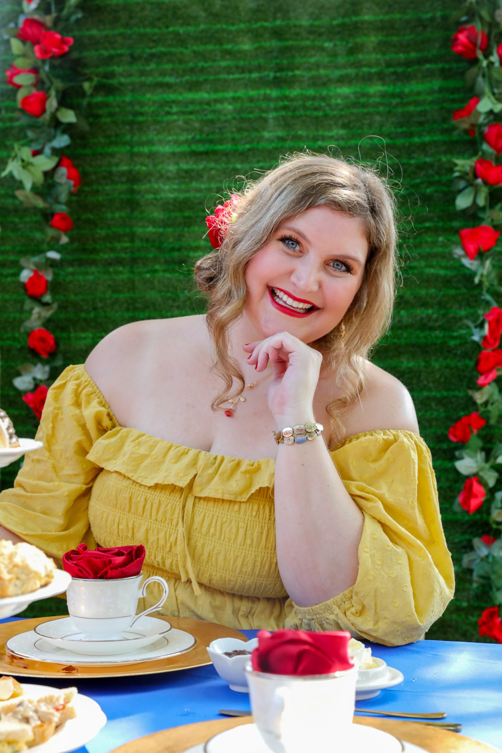 Photograph of food blogger Katie-Rose Watson resting her chin on her left hand against a green background.