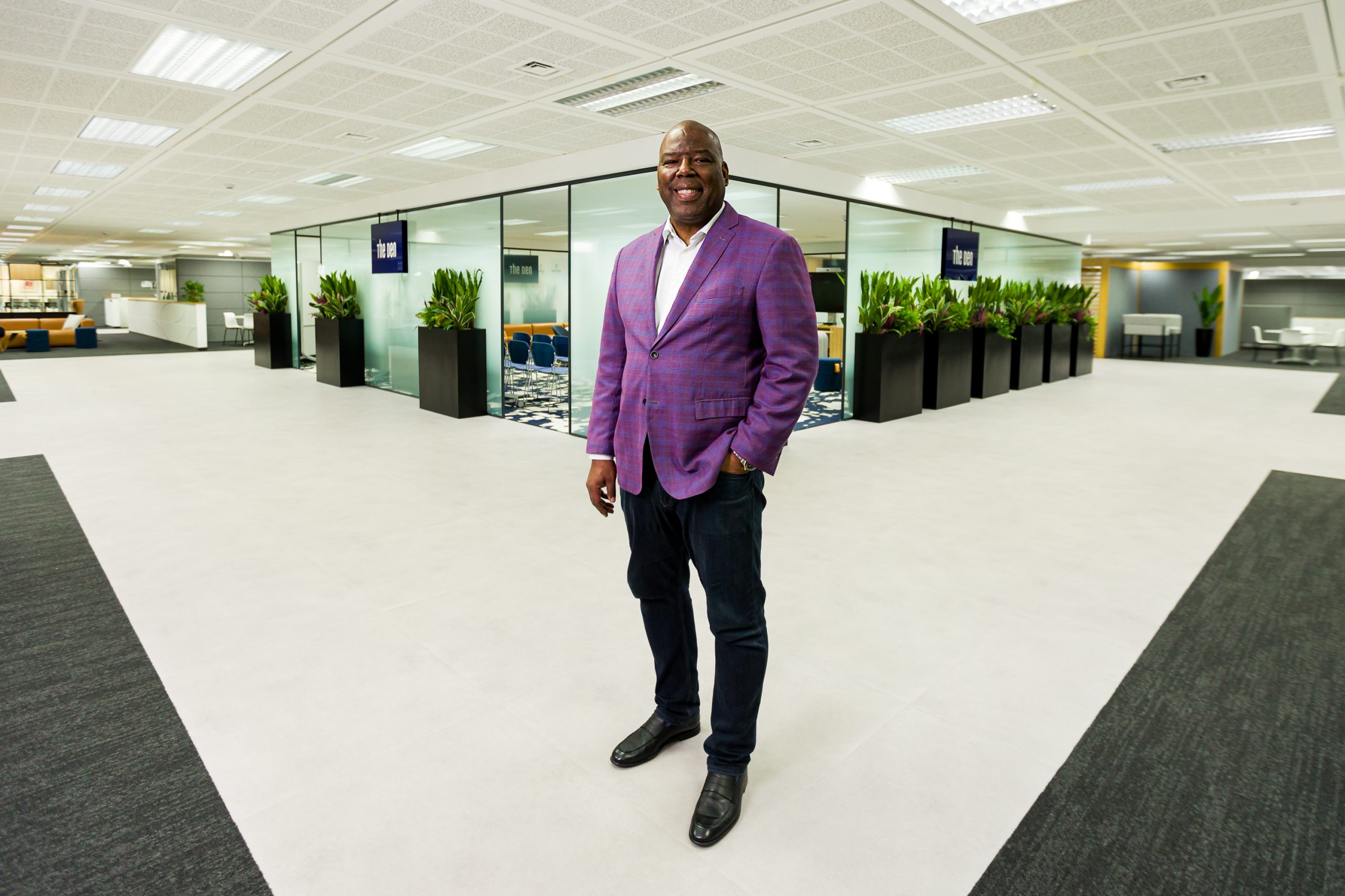 Photograph of Ford Credit Europe CEO Carlos Treadway in an office setting, his left hand in his pant pocket as he stands near a row of offices.
