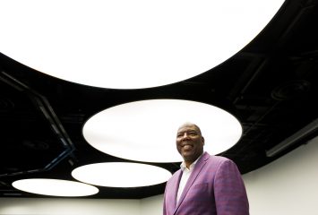 Photograph of TCU alum Carlos Treadway, executive vice president of international at Ford Credit, shot from a low angle with large, bright overhead lights in the background.