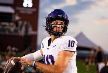 Photograph of Josh Hoover warming up before a 2024 TCU football game against Baylor in Waco, Texas, wearing a purple helmet and white jersey as he looks to his left.