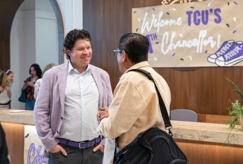 TCU Chancellor Daniel Pullin speaks with a campus community member on his first day in the role in 2025, during an event in the Harrison building.