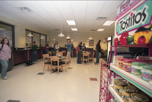 Detail photo from the Brown-Lupton Student Center, circa November 1999. A “Tostitos” brand food stand appears in the foreground, with students milling about in the background.