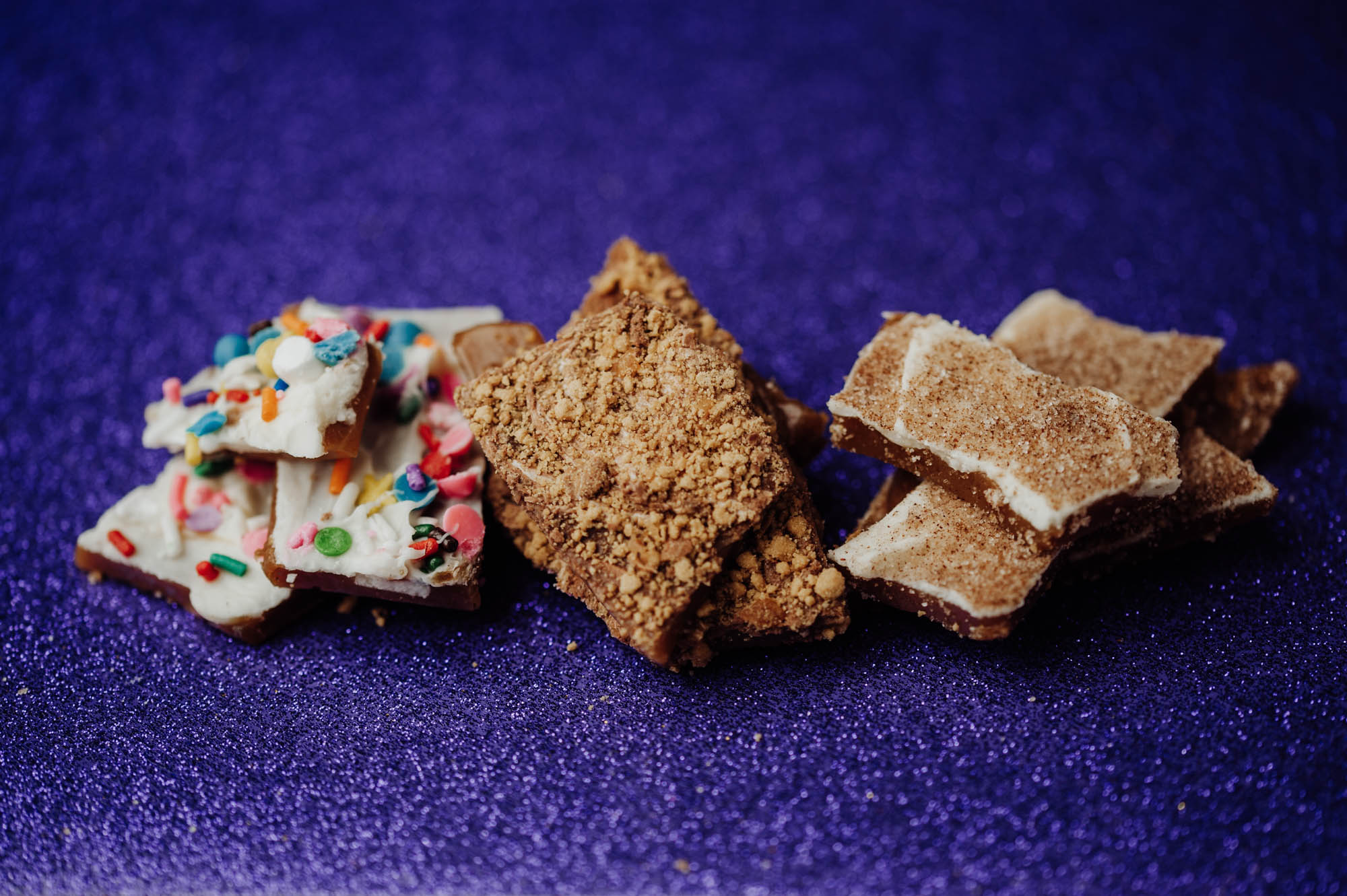 Photograph showing three varieties of toffee arranged side by side on a dark blue-purple background.