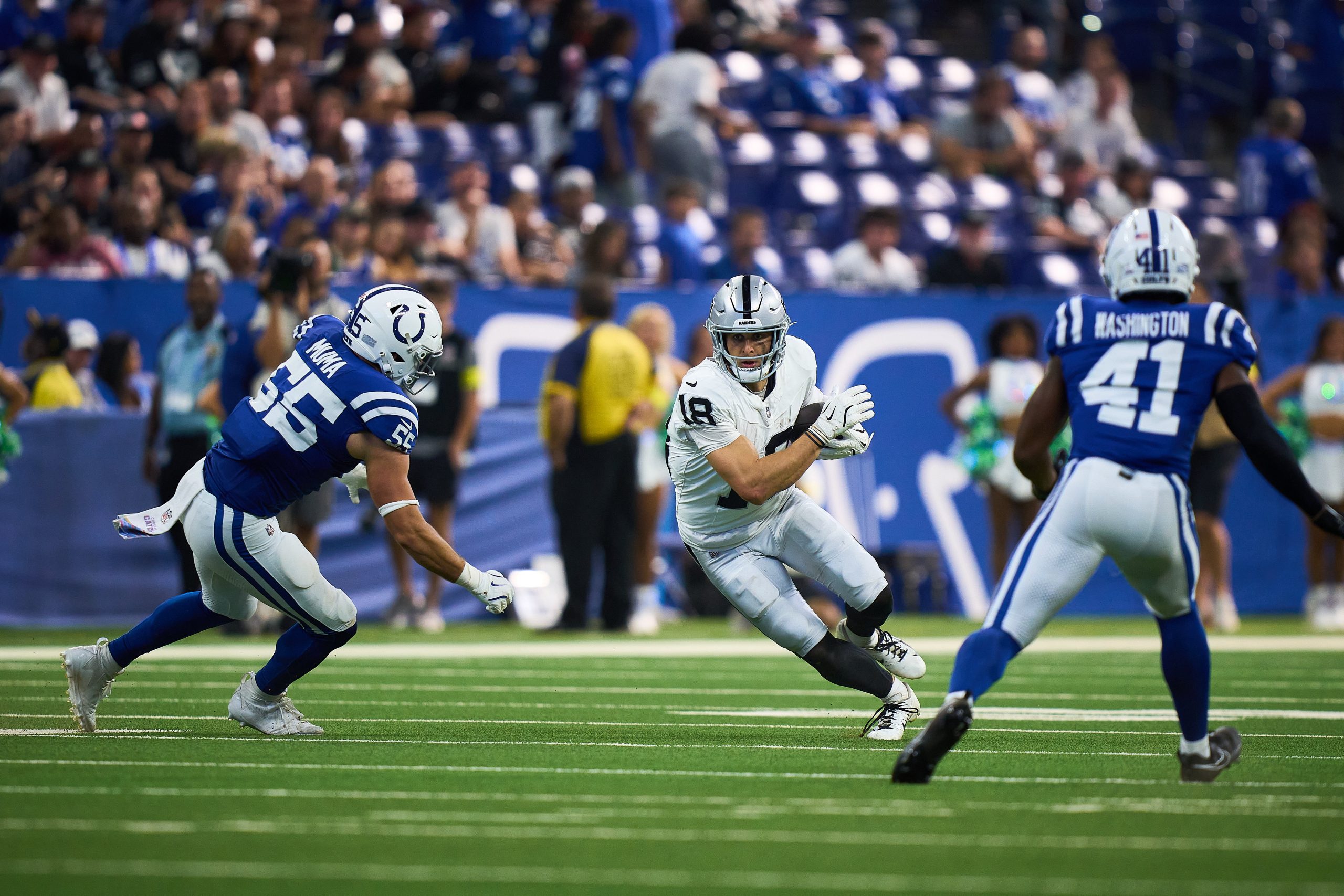 Photograph of NFL wide receiver Jack Bech in a white Las Vegas Raiders uniform (number 18) running with the ball during a 2025 regular-season game, pursued by two Indianapolis Colts defenders in blue uniforms.