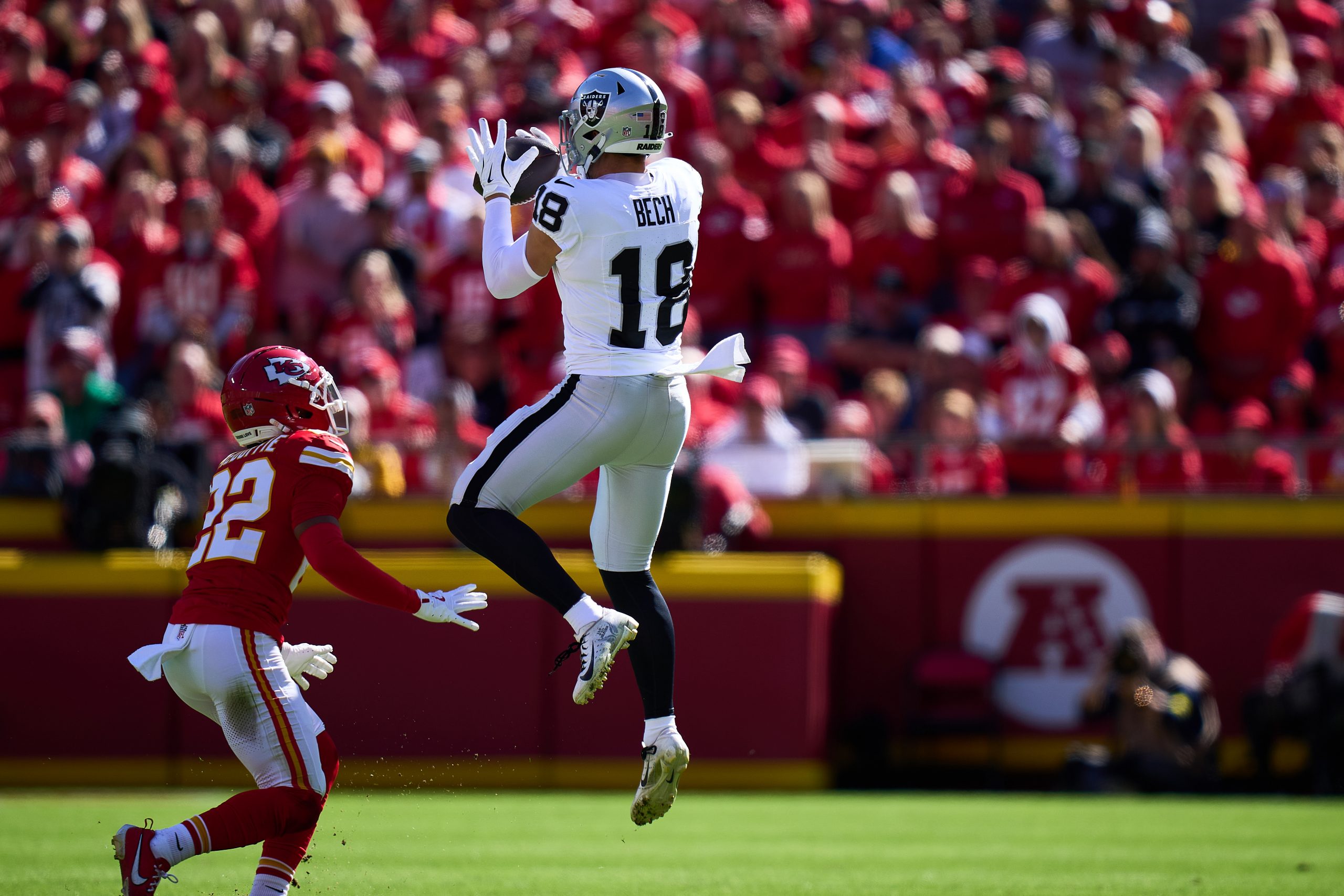 Las Vegas Raiders receiver Jack Bech corrals a pass against the Kansas City Chiefs as a defender approaches for the tackle.