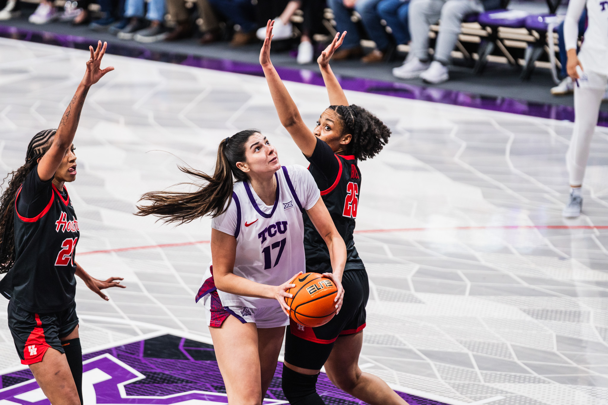 Horned Frogs basketball player Clara Silva, wearing a white No. 17 TCU jersey, attempts a basket during an NCAA game against Houston.