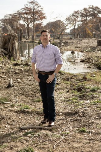 Austin Dickson stands amid the flood-damaged landscape of Louise Hays Park in Kerrville, Texas, surrounded by downed trees, debris and barren ground left by the July 4 Guadalupe River flood.