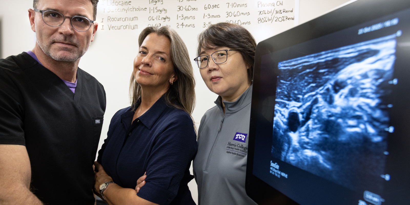 TCU Harris College of Nursing & Health Sciences researchers, from left, Gregory Collins, Vaughna Galvin and Yan Zhang stand in front of a piece of digital imaging equipment.
