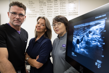 TCU Harris College of Nursing & Health Sciences researchers, from left, Gregory Collins, Vaughna Galvin and Yan Zhang stand in front of a piece of digital imaging equipment.