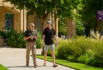 Paul Schrodt walking and talking with his son on the TCU campus.