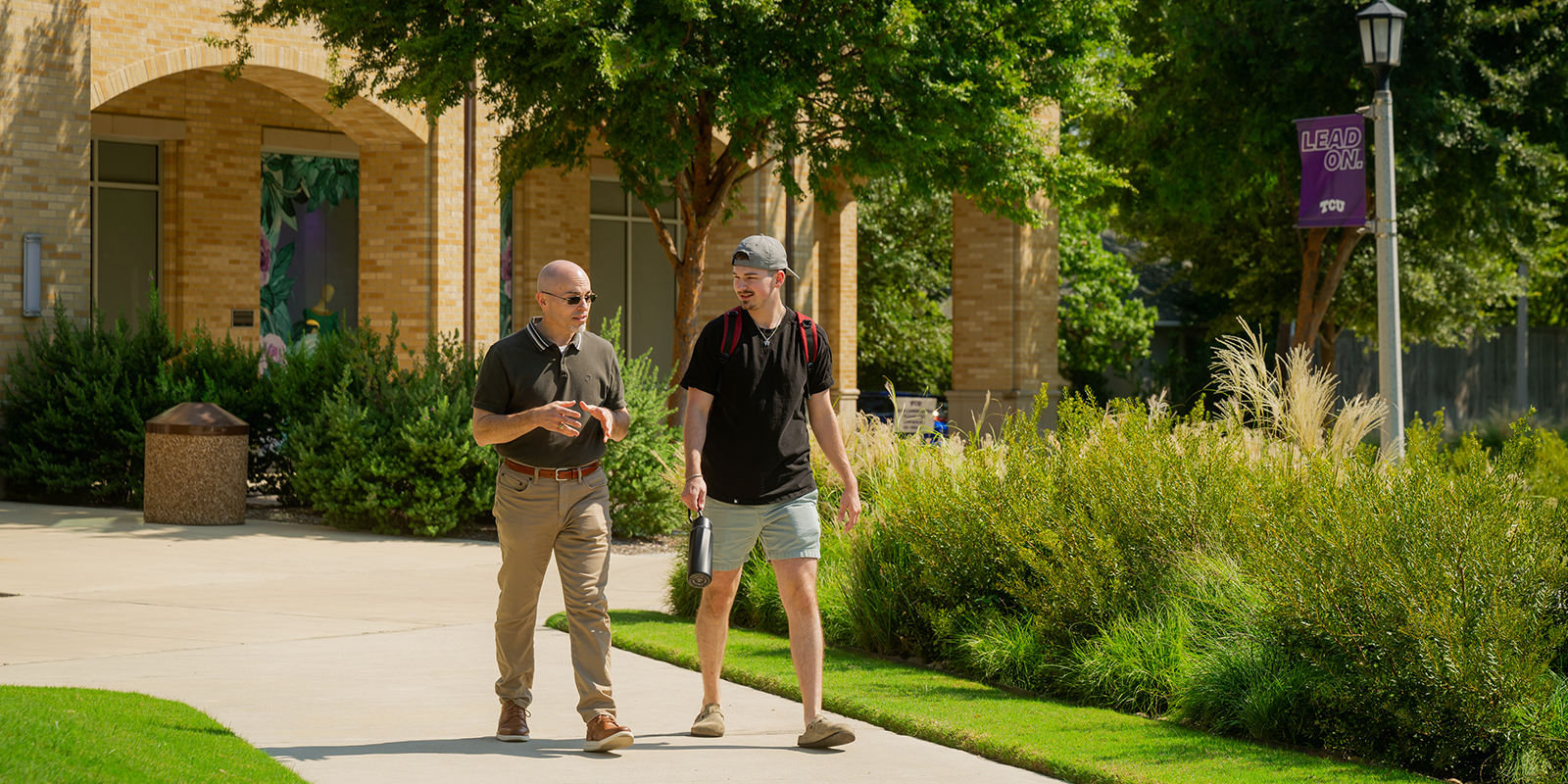 Paul Schrodt walking and talking with his son on the TCU campus.