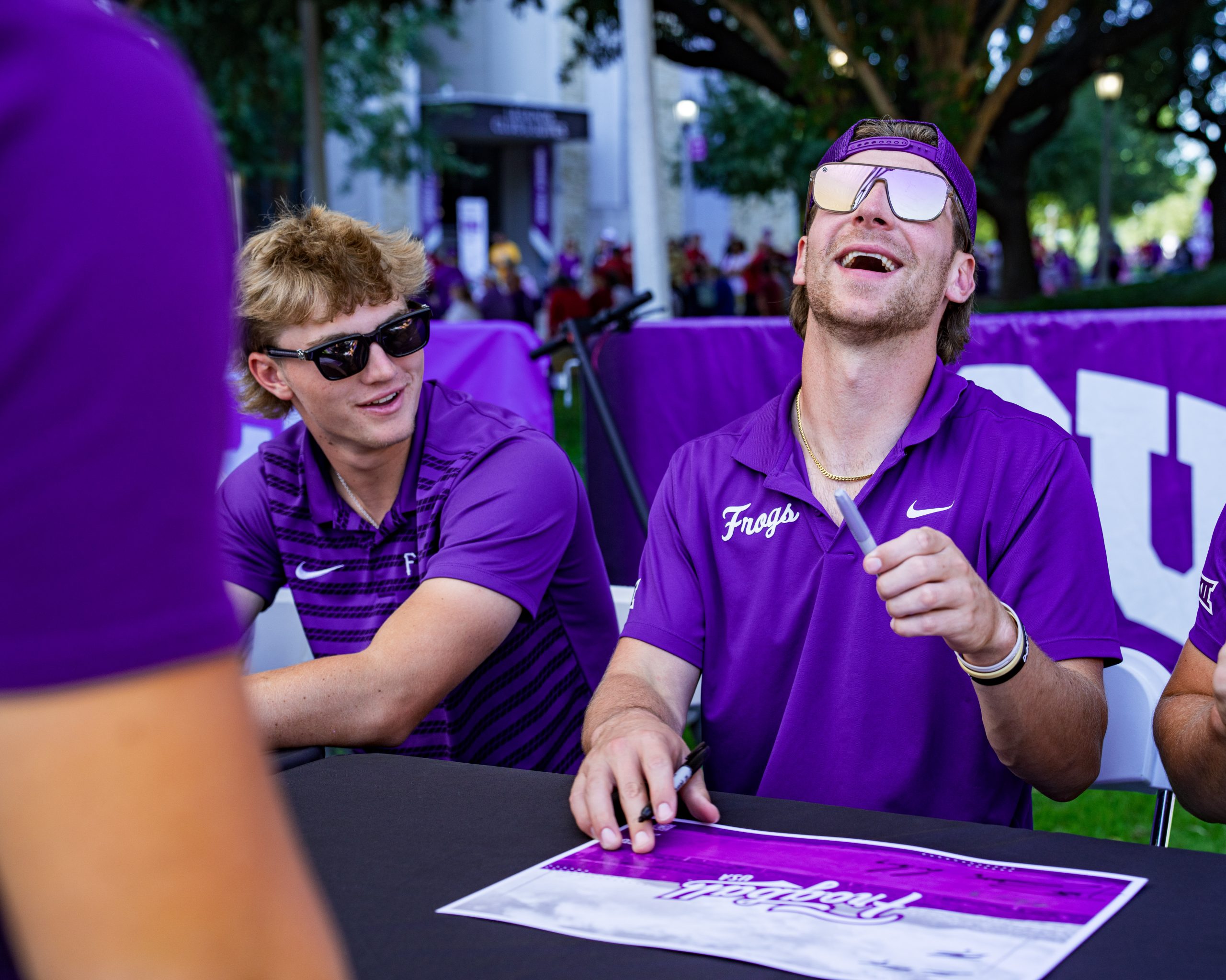 Cole Cramer laughs while signing autographs at a fan event.