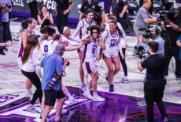 Photograph of TCU women's basketball players in white uniforms celebrating teammate Olivia Miles on the court after a second-round NCAA Tournament win.