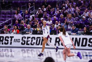 TCU women's basketball player Taylor Bigby celebrates on the court during the NCAA Tournament first round as a packed arena of purple-clad Horned Frog fans erupts behind her. Teammate Marta Suárez runs toward her in the foreground.