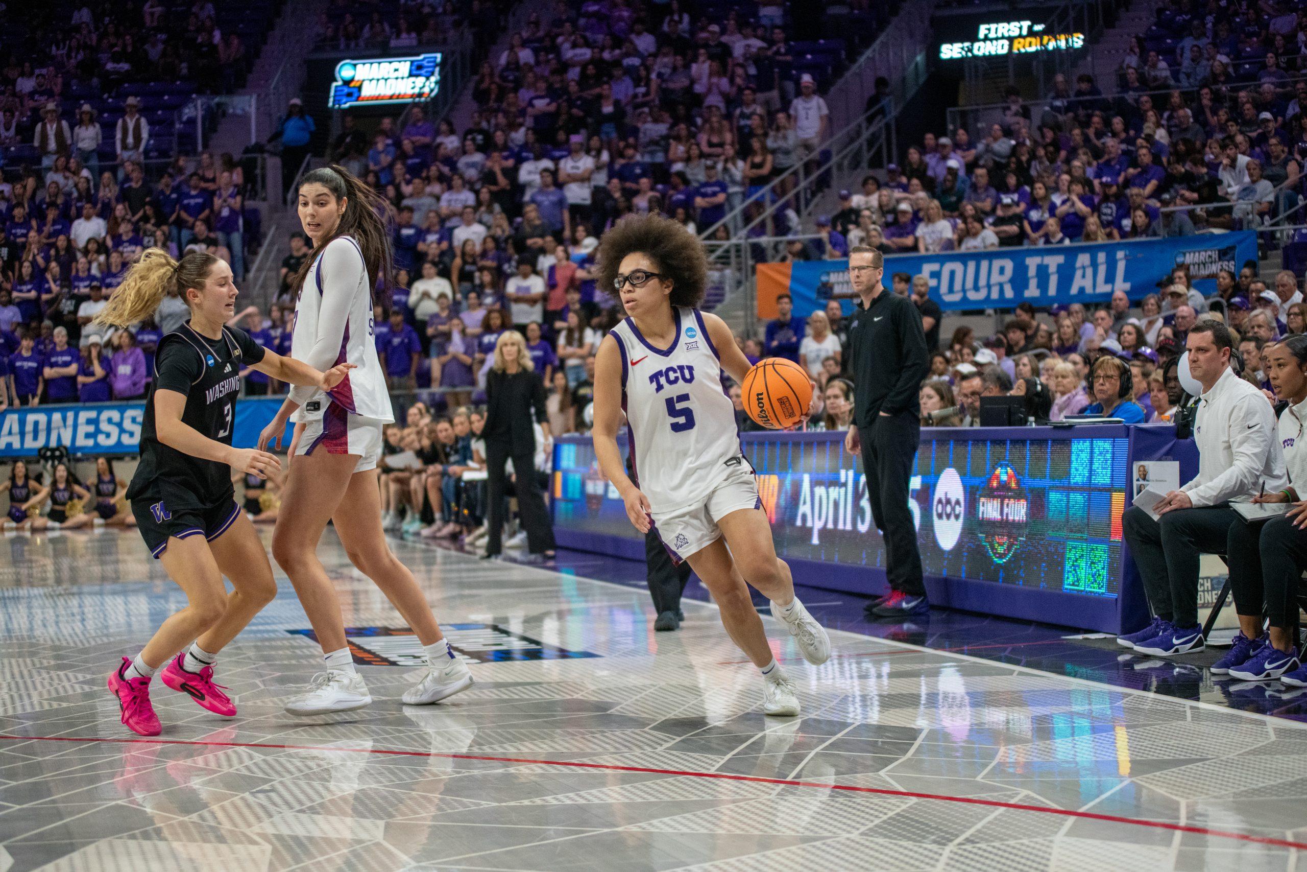 Olivia Miles dribbles toward the basket as teammate Clara Silva sets a pick on a Washington defender, eyes on the hoop, ball in her left hand.