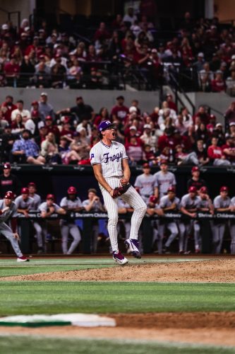 TCU pitcher Noah Franco celebrates on the mound after recording a big out against Arkansas, pumping his fist and shouting in front of a packed crowd at a neutral-site game.