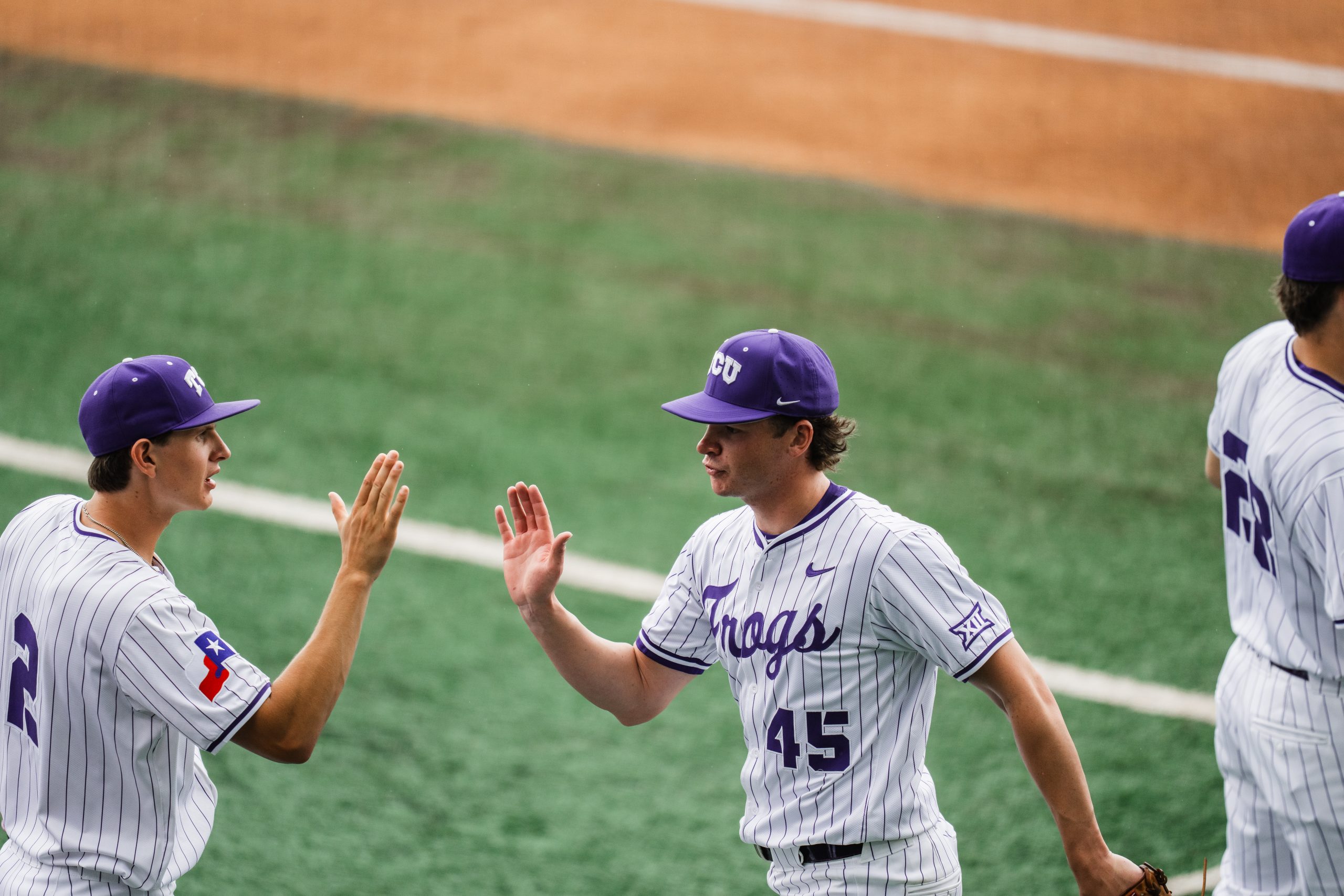 TCU pitcher Lance Davis high-fives a teammate after coming off the field during a Big 12 game against Arizona in April 2026.
