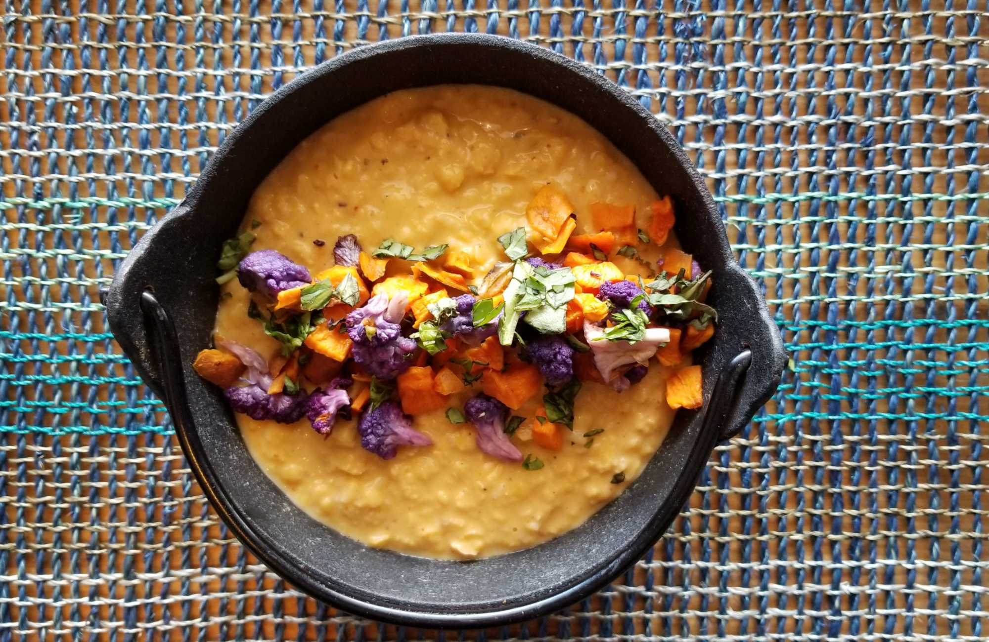 A plant-based dish topped with roasted vegetables and herbs from The Vegan Taste.