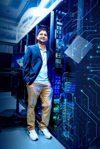TCU professor Robin Chataut stands in front of computer servers in a data center, with digital circuit graphics overlaid on the image.